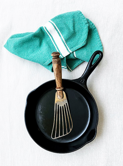 Overhead photograph of a cast iron pan with a metal spatula